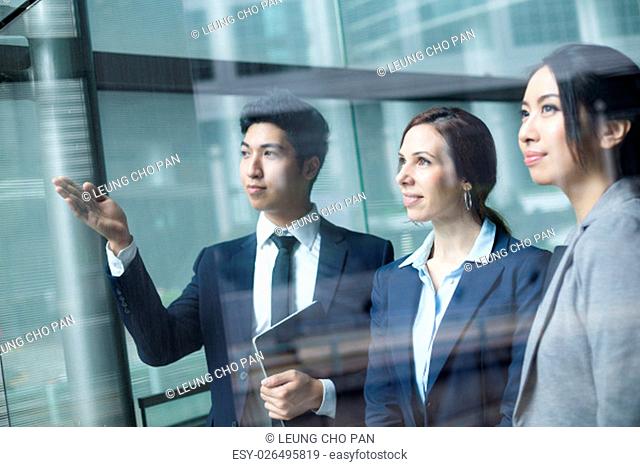 Group of business people looking though window