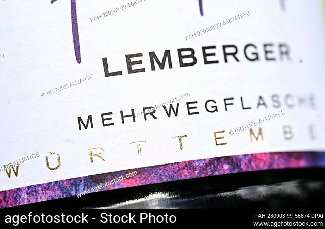 PRODUCTION - 01 September 2023, Baden-Württemberg, Schwaigern: The label of a 0.75 liter refillable wine bottle (l) from the Heuchelberger Weingärtner...