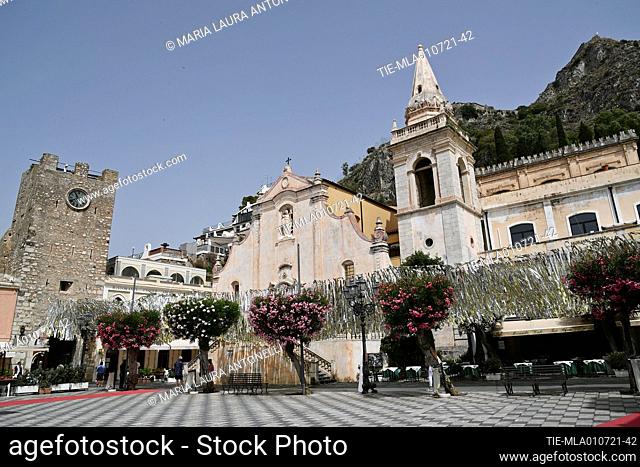 Piazza IX Aprile with the Baroque church of San Giuseppe (17th century) and the Clock Tower or Porta di Mezzo in Taormina , ITALY-01-07-2021