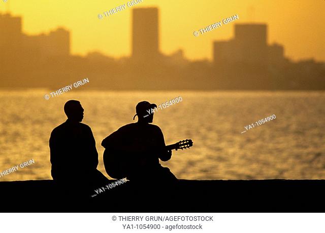 Local musician playing blues music at Goree island during sunset. Background, capital city Dakar. Senegal, West Africa