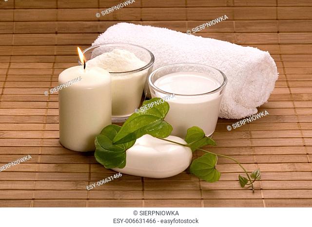 white bath items. soap, towel, milk, candle. spa