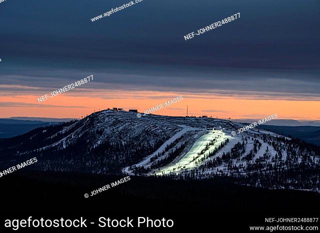 Illuminated ski piste at sunset