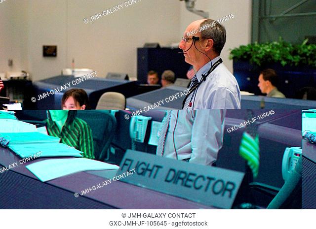 In the Shuttle (White) Flight Control Room of Houston's Mission Control Center, flight director Paul Dye (right) and spacecraft communicator (CAPCOM) Megan...