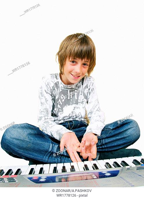 Cute kid playing piano, isolated