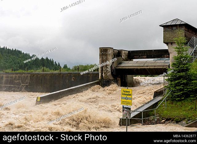 High water at the hydropower plant in Krün on the Isar River in the Bavarian Alps. The brown water flows through the plant