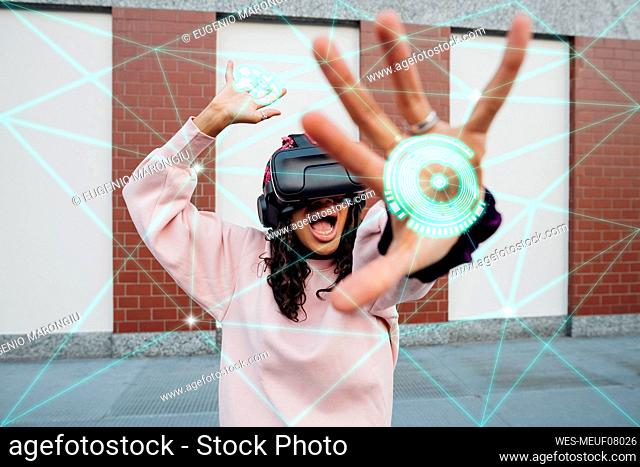 Young woman with virtual reality glasses gesturing in front of transparent screen