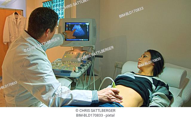 Doctor using ultrasound on pregnant woman