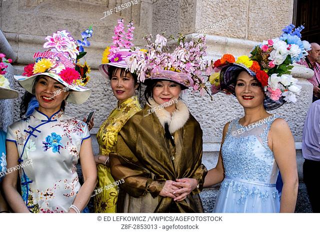 New York, NY - April 16, 2017. A group of Asian women in elaborate hats on the steps of St. Patrick's Cathedral at New York's annual Easter Bonnet Parade and...