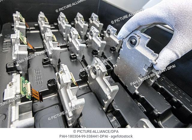 02 March 2018, Germany, Ingolstadt: A worker checking the production of a multi-function camera at Continental factory. Photo: Armin Weigel/dpa