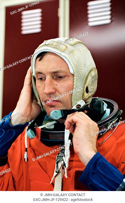 Cosmonaut Sergei Y. Treschev, Expedition Five flight engineer representing Rosaviakosmos, dons his training version of the shuttle launch and entry suit prior...