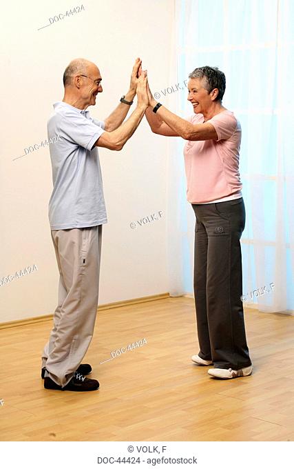 older woman and olde man doing gymnastics together - seniors - flexibility