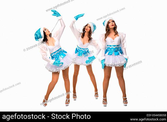 Attractive young female dancers in show costumes of snow maiden posing on white background