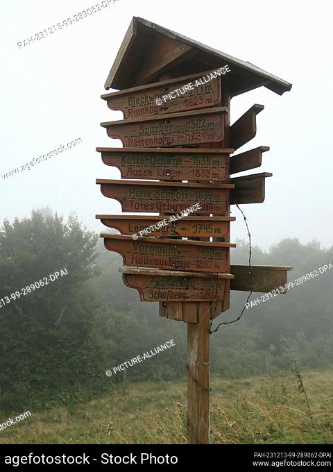 27 August 2023, Austria, St. Gilgen: A wooden sign with numerous signposts to hiking trails to mountains in the surrounding area
