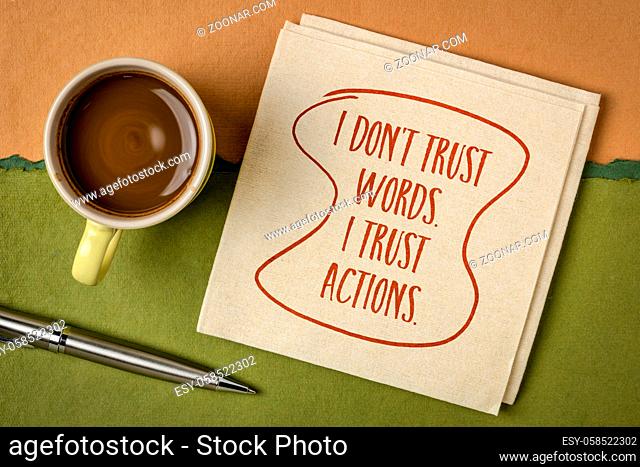 I do not trust words. I trust actions. Inspirational handwriting on a napkin with a cup of coffee. Personal development concept