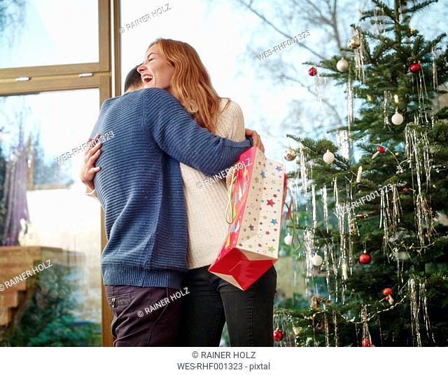 Couple standing in front of Christmas tree