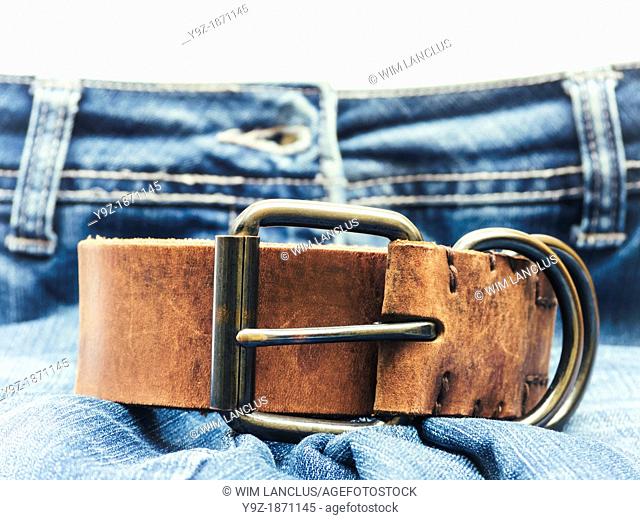 Jeans with brown leather belt in foreground
