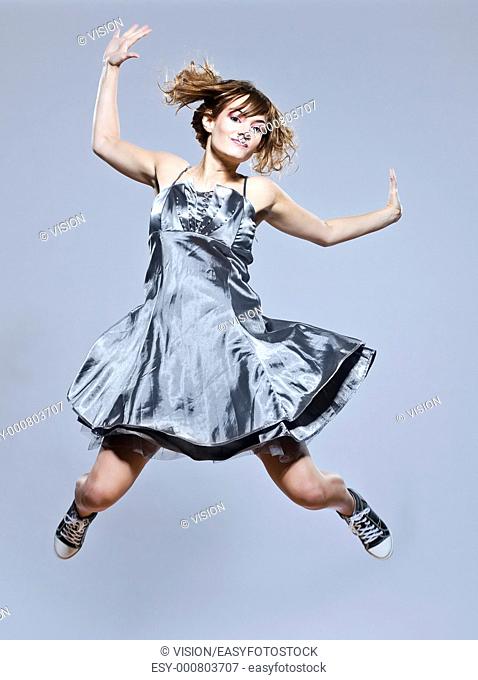 beautiful young caucasian woman girl evening dress jumping happy on studio isolated plain background