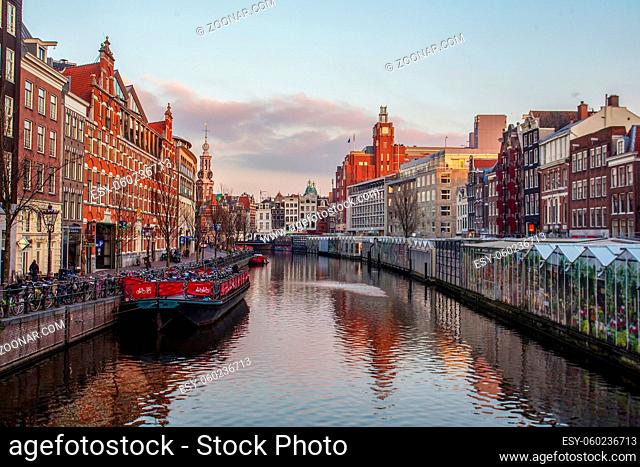 Amazing classic view of the Amsterdam Canal at sunset! boat parking for bicycles