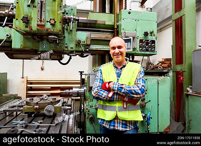 Stolzer Metallarbeiter als Maschinist vor der Koordinatenbohrmaschine in der Metallfabrik