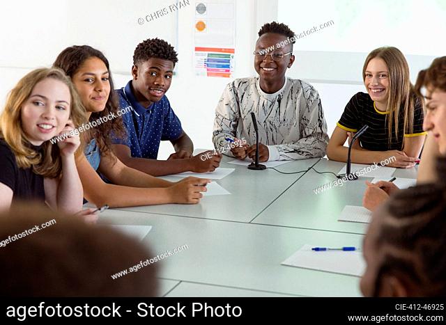Smiling high school students listening in debate class
