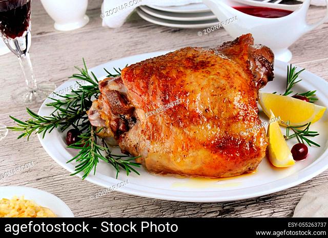 Baked turkey thigh, on the table with cranberry sauce