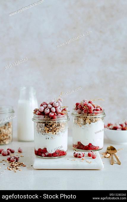 Granola in a jar with yogurt and red currants
