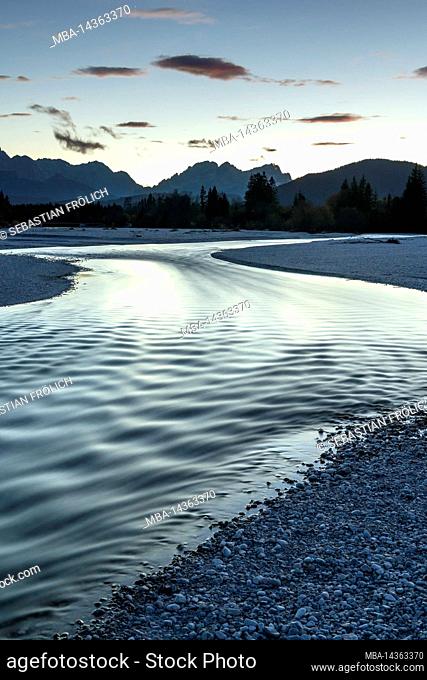 The Isar in Werdenfelser Land, surrounded by the Bavarian Alps. The evening light is reflected in the water, which flows through the shallow gravel bed with...