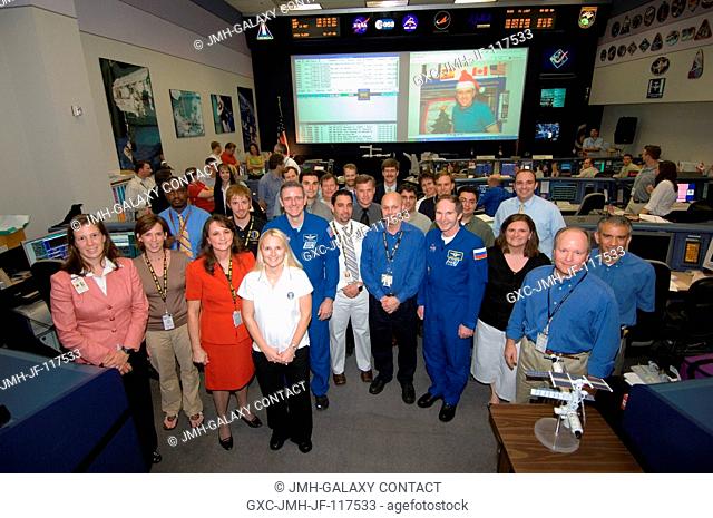 The Expedition 12 crewmembers and flight controllers pose for a group portrait in the Station (Blue) Flight Control Room in Houston's Mission Control Center...