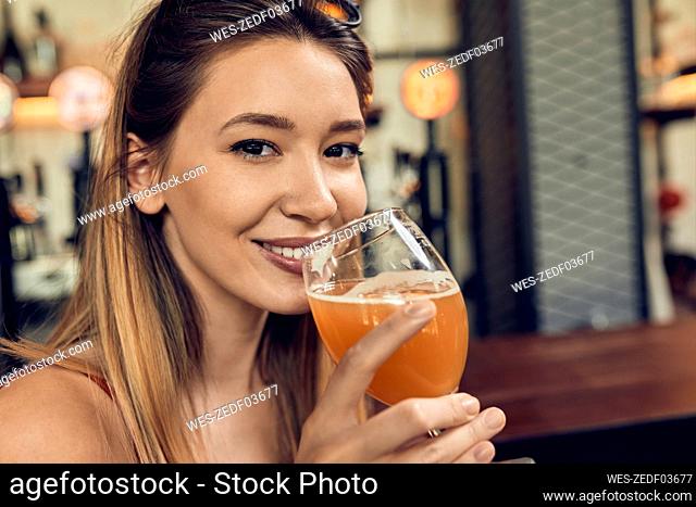 Portrait of a smiling woman in a pub having a beer