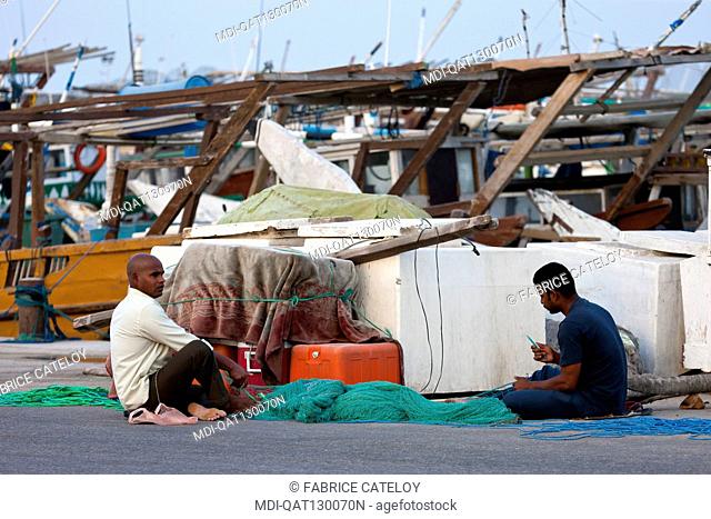 Qatar - Al Khor - The fishing port - Fishermen mending fishnets