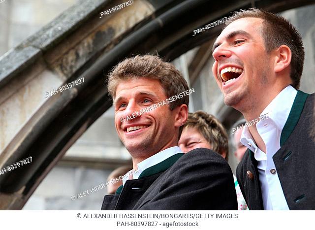 MUNICH, GERMANY - MAY 15: Thomas Mueller of Bayern Muenchen and his team mate Philipp Lahm (R) celebrates winning the German Championship title on the town hall...
