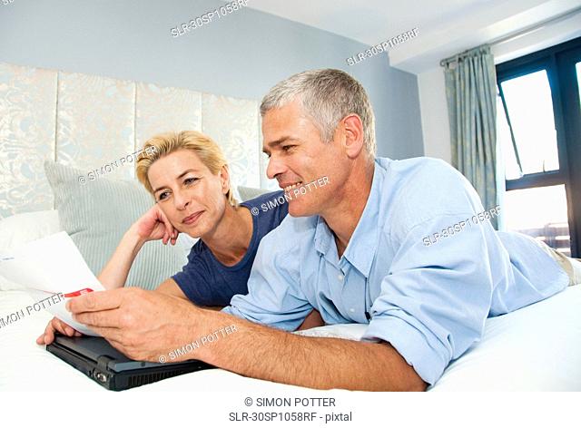 Happy couple look at bills