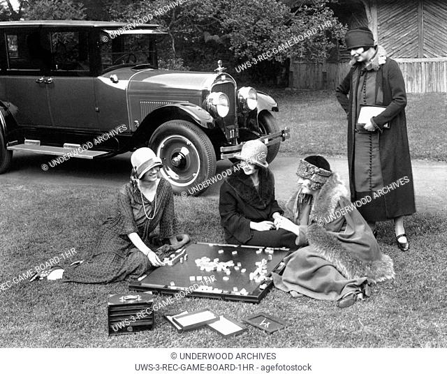 California: 1924.Four well dressed young women playing mahjong outdoors on a lawn