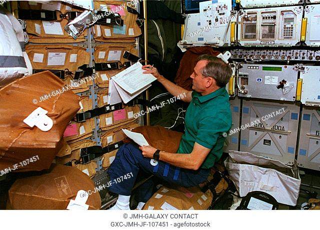 Astronaut Thomas D. Akers, in the Spacehab, goes over an inventory of supplies which will be transferred to the Russia's Mir Space Station