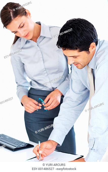Handsome business man with female colleague reviewing document at workplace