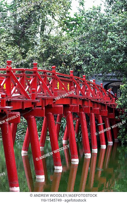 The red Huc Bridge reflected in in Hoan Kiem Lake leads to Ngoc Son island Jade Mountain Confucian temple Hanoi Vietnam
