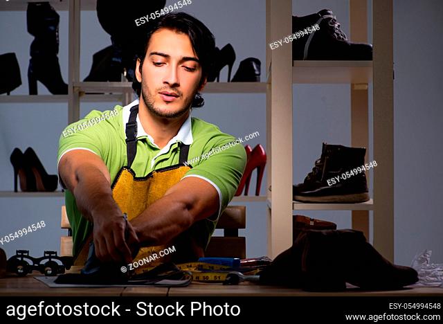 Young shoemaker in workshop at night