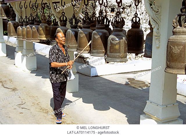 In the temple of Wat Phra Phutthabat. the interior courtyard has a row of large cast iron prayer bells which worshippers strike while saying their prayers to...