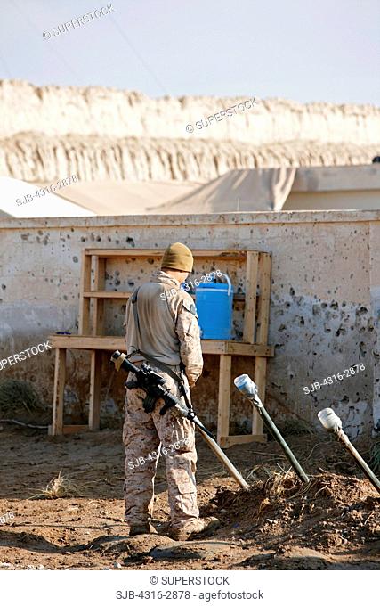 A U.S. Marine urinates into a 'piss tube' at a combat outpost in southern Afghanistan's Helmand Province