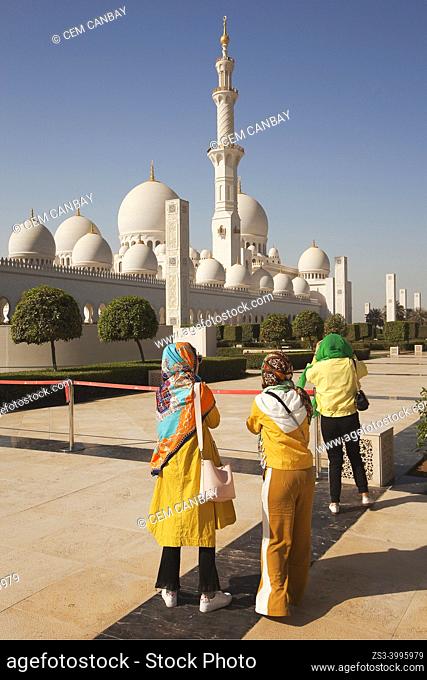 Visitors with headscarfs in front of the Sheikh Zayed Bin Sultan Al Nahyan Mosque, Abu Dhabi, United Arab Emirates, Middle East