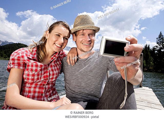 Germany, Bavaria, Couple taking self photograph, smiling