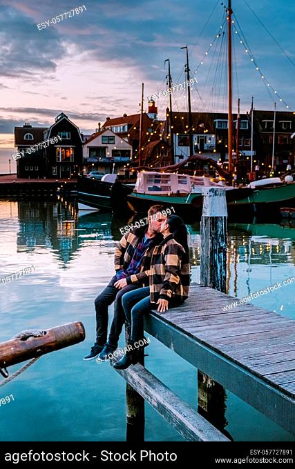 Urk Flevoland Holland, couple men and woman watching sunset at the small fishing village harbour of Urk Netherlands Europe