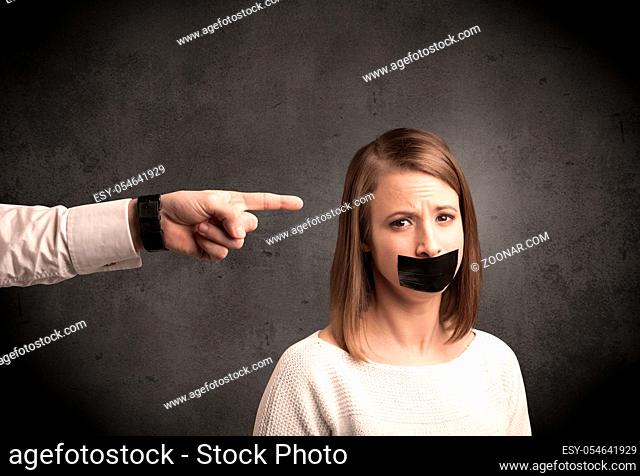 Caucasian business hand pointing at female employee with grunge background