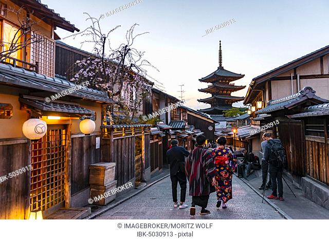 Pedestrian with kimono, Yasaka dori historical street in the Old Town with traditional Japanese houses, behind five-storey Yasaka pagoda of the Buddhist Hokanji...