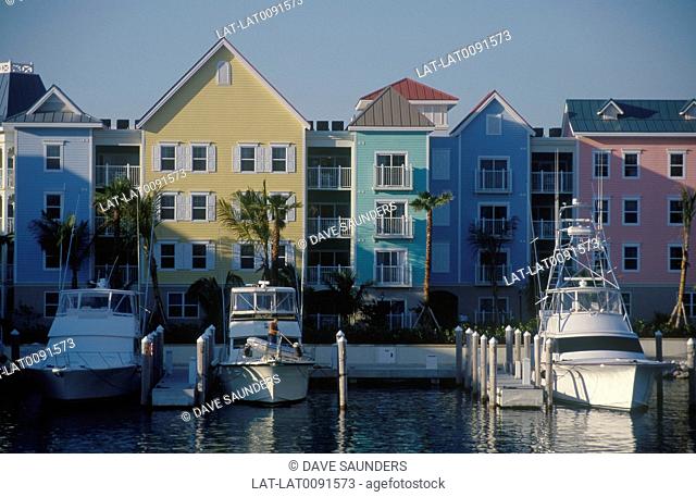 Resort town houses painted bright colours. Boats moored