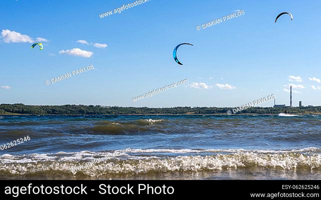 Kitesurfers flying over the lake. Kiteboarding (kitesurfing) on a beautiful sunny and windy day