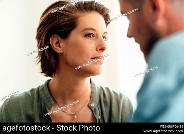 Suspicious woman looking at man