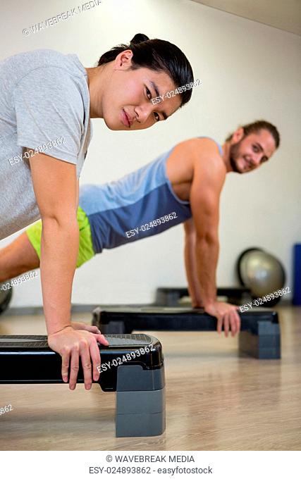 Portrait of two men doing aerobic exercise on stepper