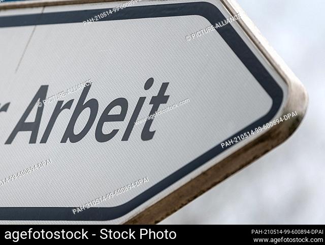 06 May 2021, Saxony-Anhalt, Sangerhausen: ""Work"" is written on a signpost in front of the employment agency in Sangerhausen