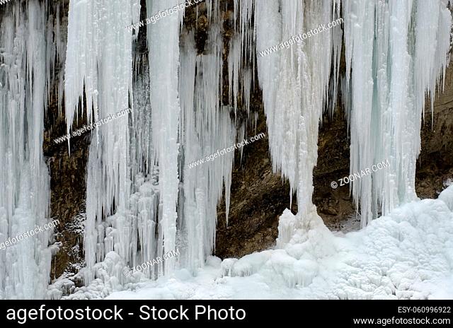Frozen beautiful waterfall in winter. Icicles and mountain river